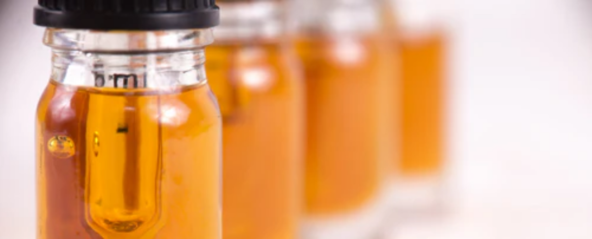 Four bottles of CBD oil with orange liquid
