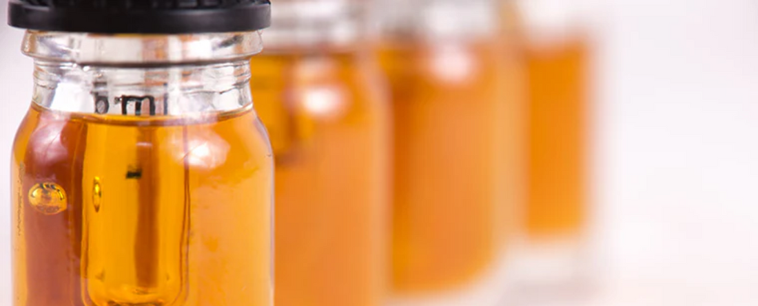Four bottles of CBD oil with varying amber colors.