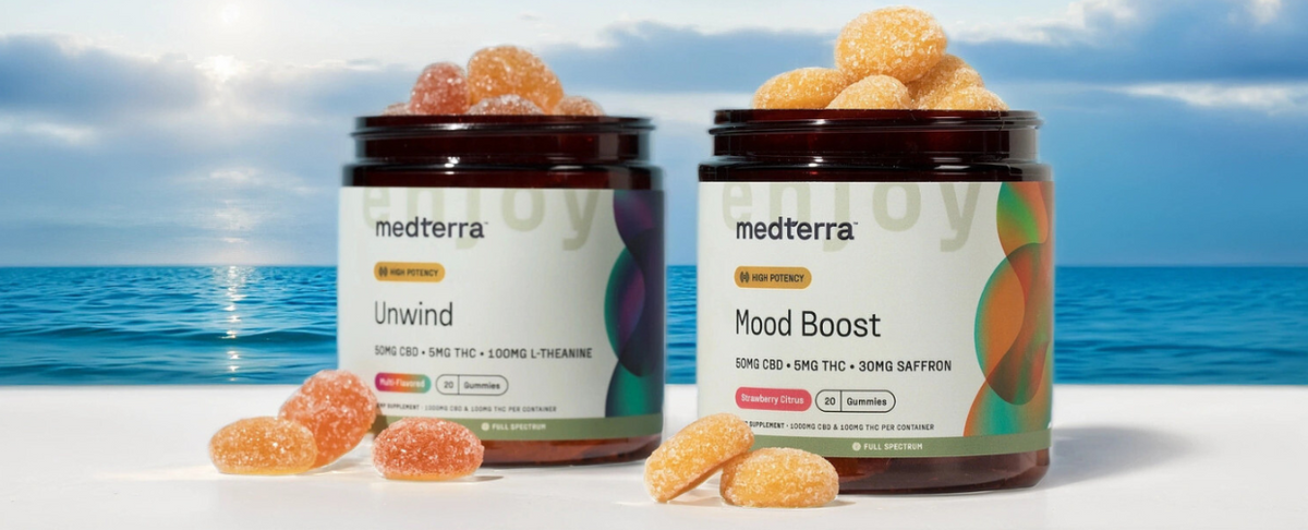 Two jars of Medterra CBD gummies labeled 'Unwind' and 'Mood Boost' against a beach background.