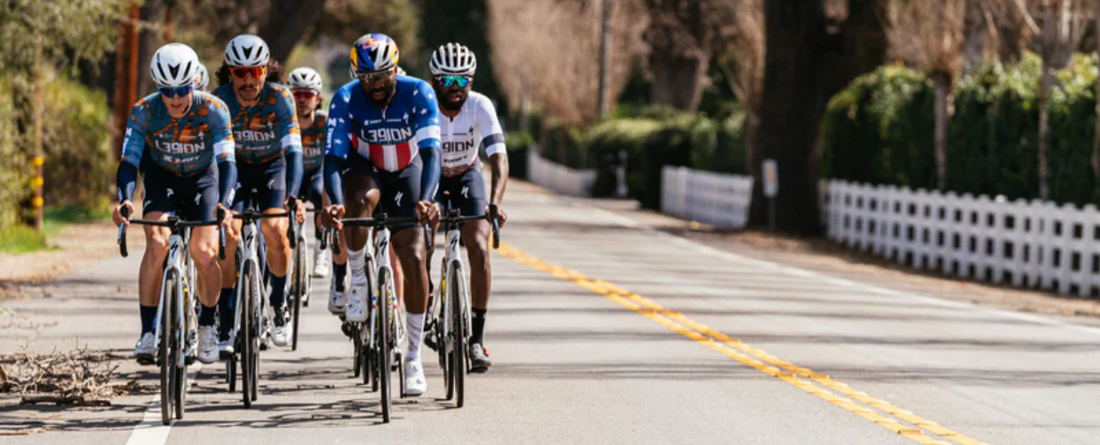 A group of cyclists from L39ION of Los Angeles riding on a road.