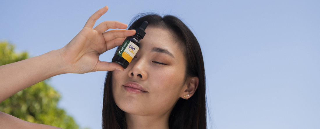 A woman applying CBG oil to her face, promoting relaxation and calmness.