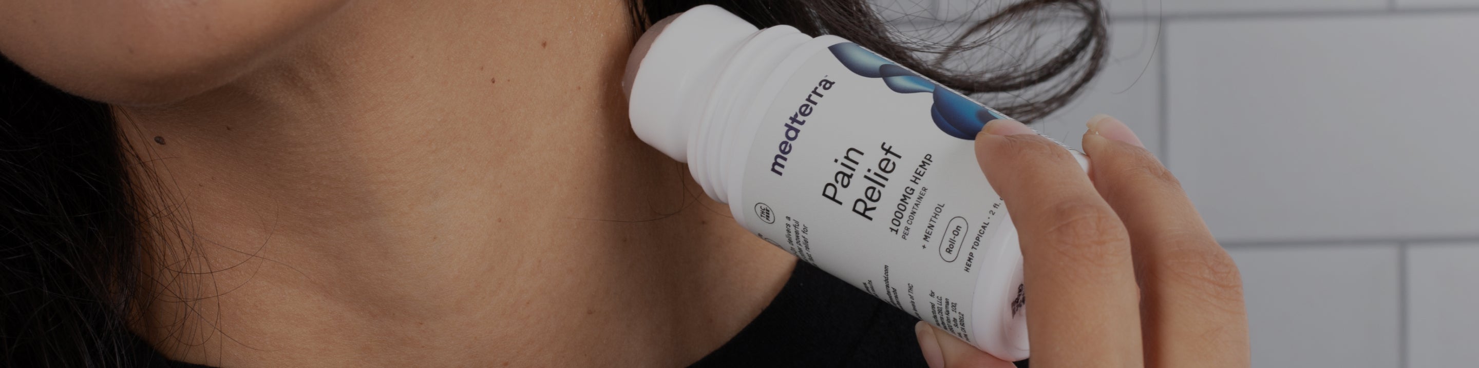 Applying roll-on to neck; label: medterra Pain Relief 1000MG HEMP per container MENTHOL Roll-on HEMP TOPICAL