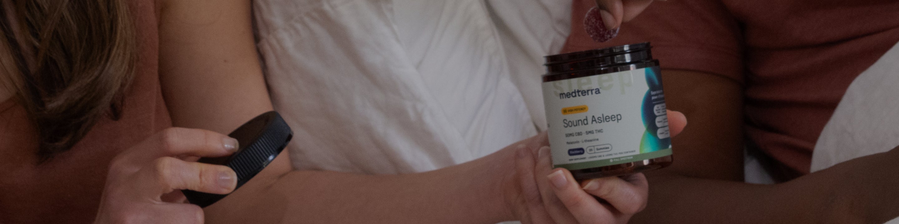Two people holding an open Medterra "Sound Asleep" supplement jar and its lid.