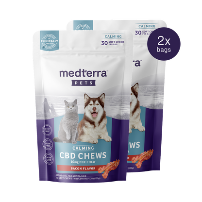 Two packs of Medterra's Pet CBD Calming Chews are displayed, each containing 30 bacon-flavored soft chews with 10mg of Pet CBD and L-Tryptophan per chew. The package showcases a cat and a dog, highlighting calming benefits and clinical testing.