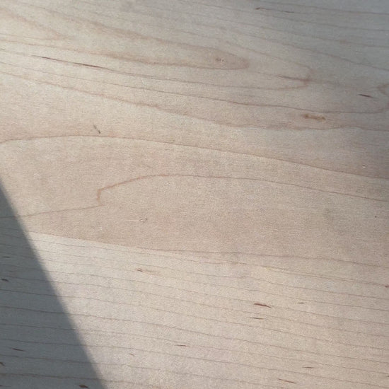 Daily Relief CBD Isolate Oil on a wooden surface with a shadow cast diagonally