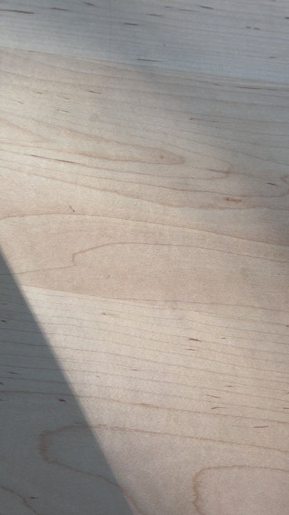 Daily Relief CBD Isolate Oil on a wooden surface with a shadow cast diagonally